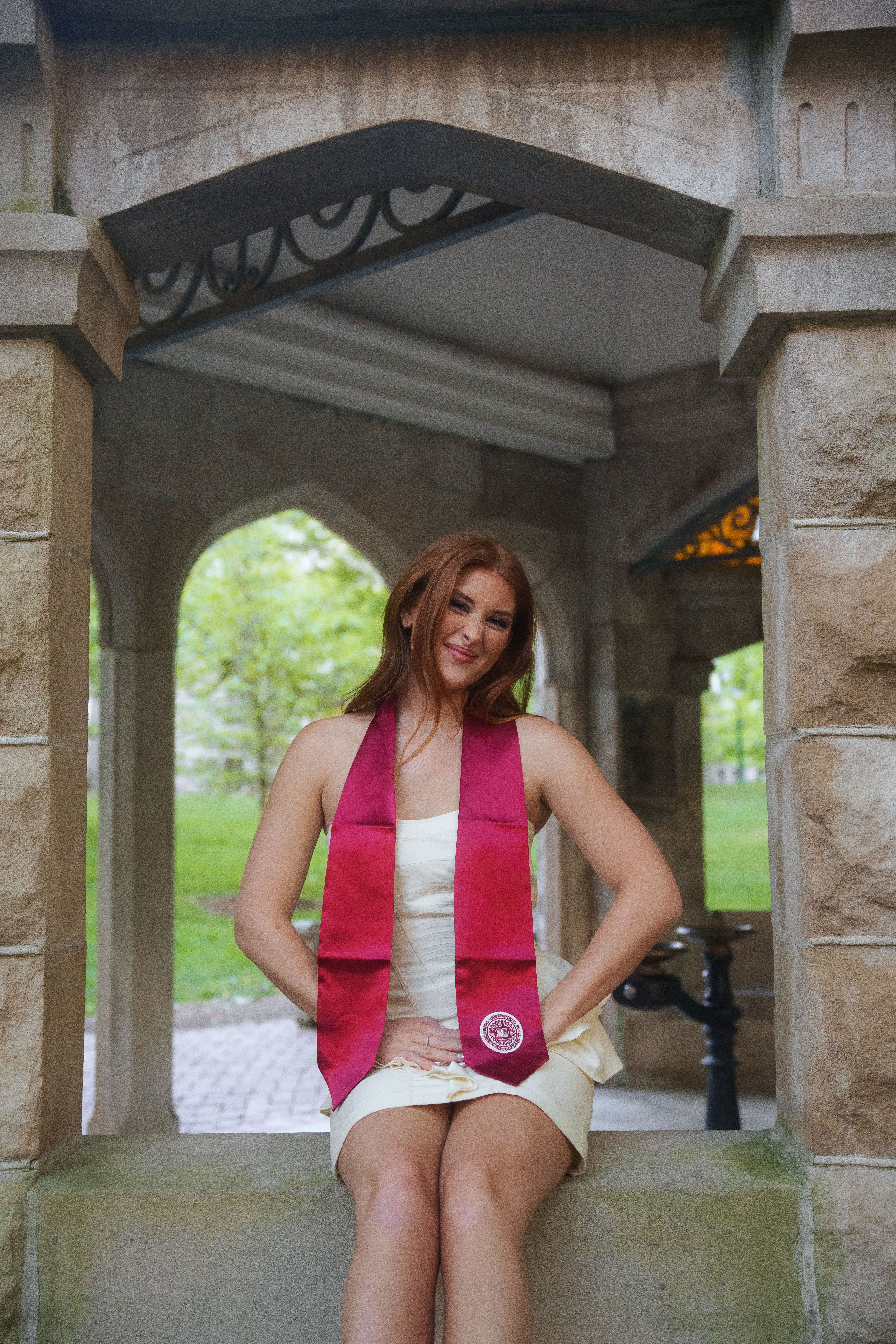 Three graduates in white dresses at sunset.