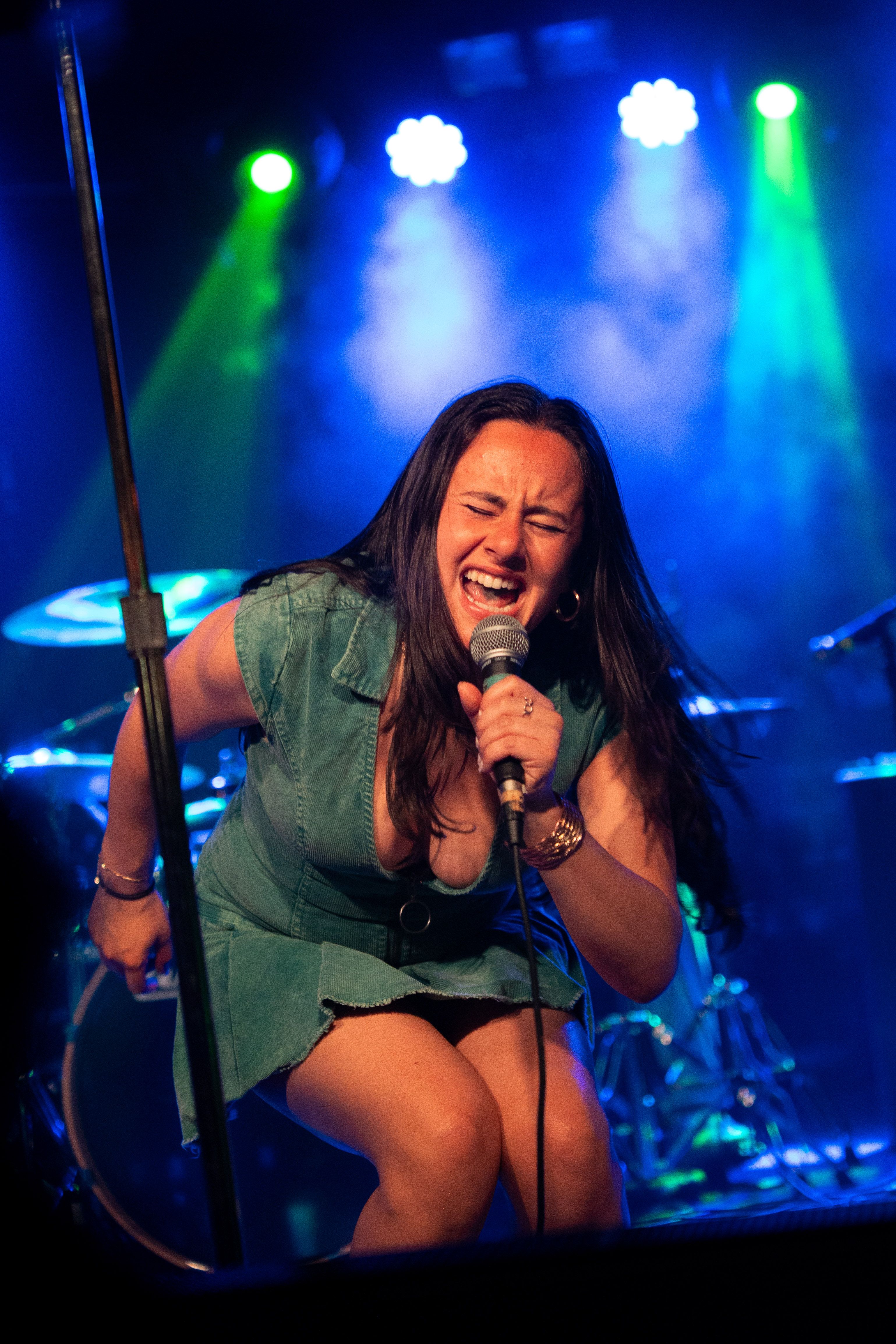 Singer kneeling at the edge of the stage.