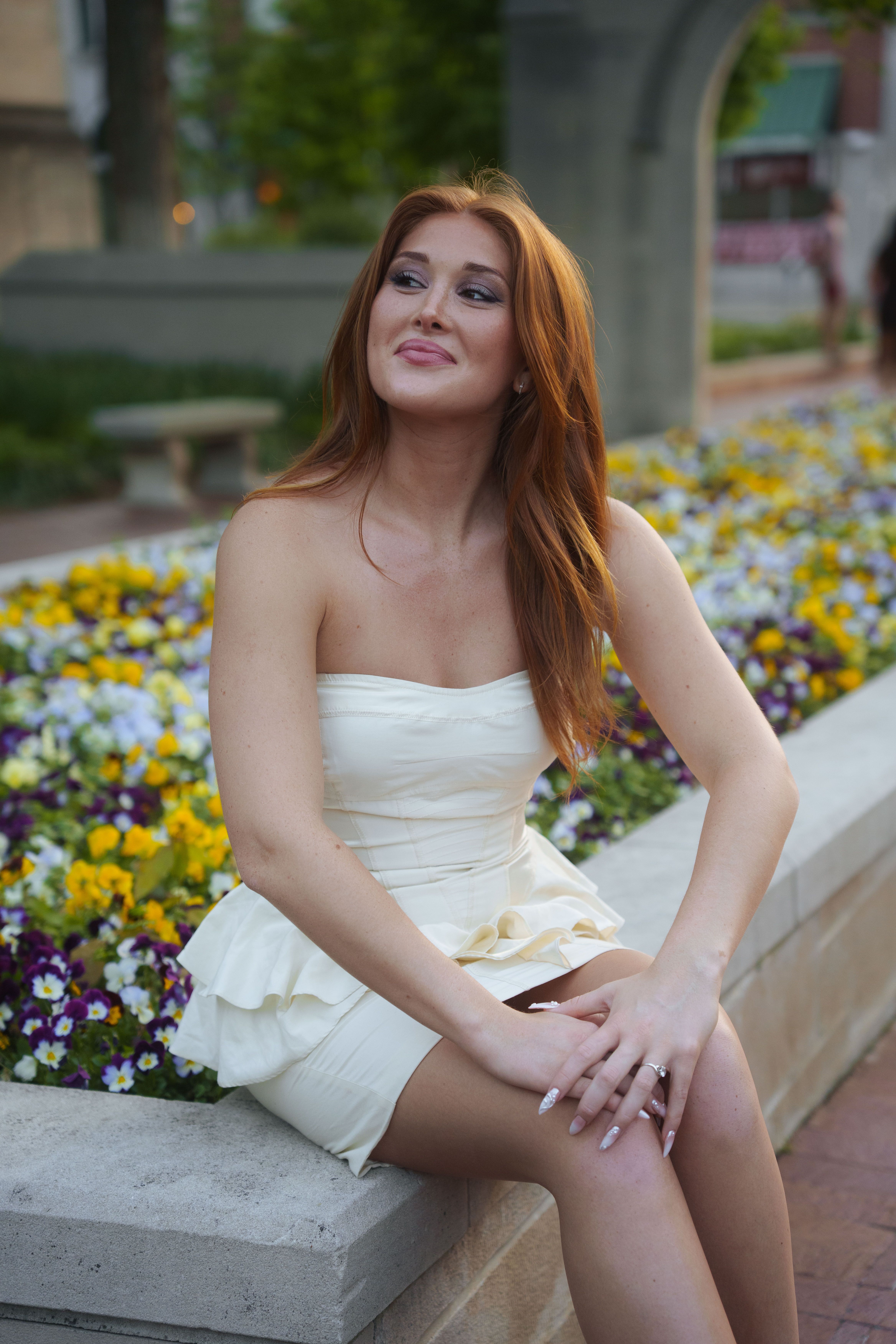 Three graduates in white dresses at sunset.